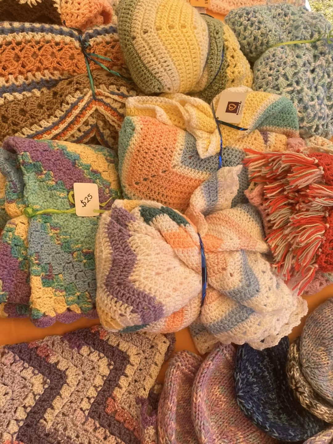 Pile of hand-knitted beanies and blankets