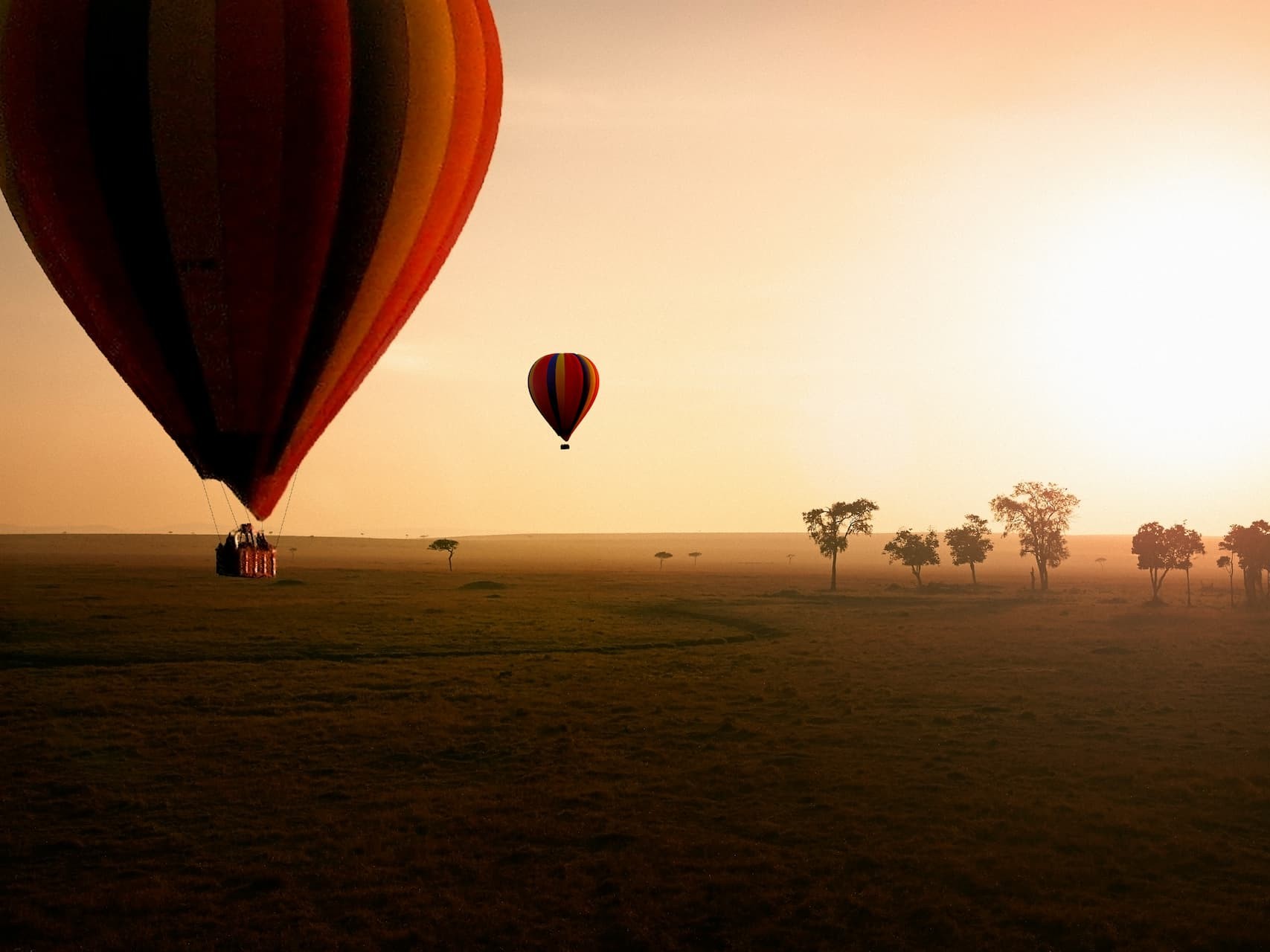 A hot-air balloon drifting over the East African plains at sunrise