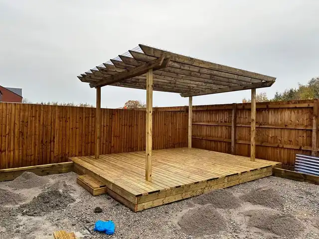 Block paving area being laid in a garden with a play frame behind