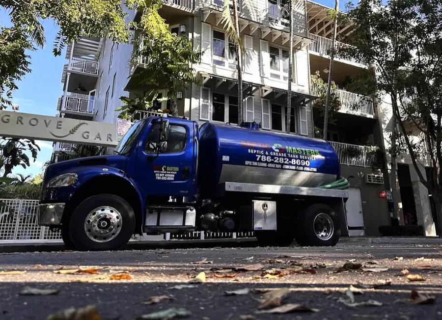 Blue Septic Masters pump truck parked on a residential street in Coconut Grove, Miami