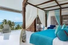 Master Suite (Sea View) at Ayurvie Weligama with canopy bed and private balcony overlooking palm trees and ocean.
