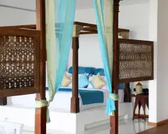 Master Suite (Sea View) at Ayurvie Weligama with traditional wooden canopy bed and vibrant décor.