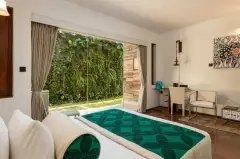 Courtyard room at Ayurvie Weligama with a bed beside glass doors opening to a private courtyard.
