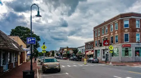 Street with brick storefronts and overhead clouds