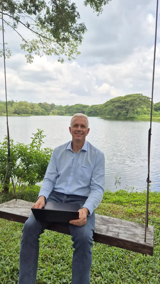 Peter Weiss seated beside a lake in Thailand.