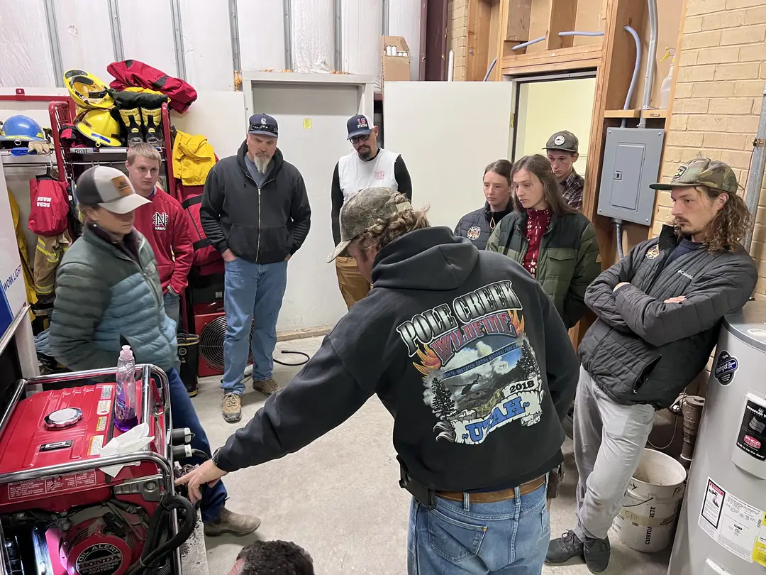 Crew gathered around equipment during training inside the fire station