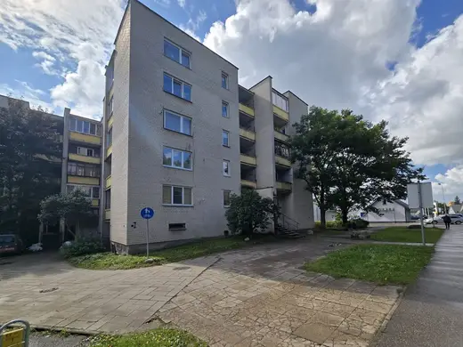 Daugiabutis namas su žaliu kiemu