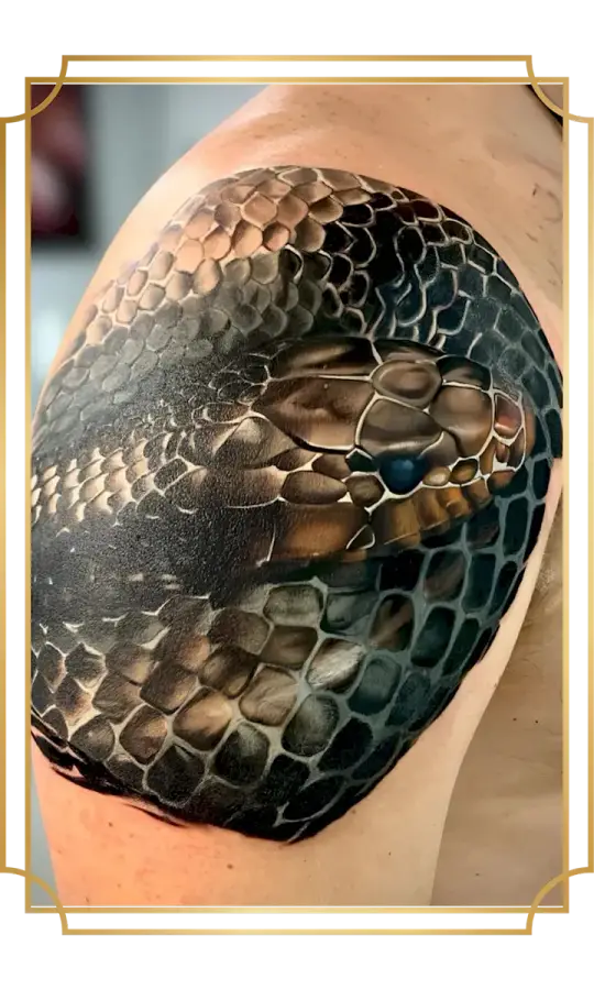 Realistic coiled snake cover-up tattoo wrapping the shoulder and upper arm with detailed scales