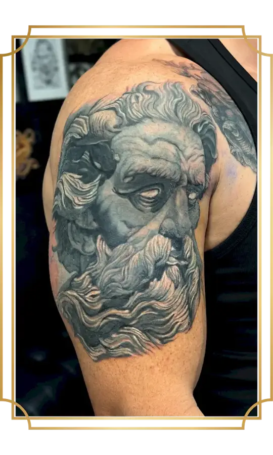 Black and gray realism tattoo of a bearded classical figure on the upper arm