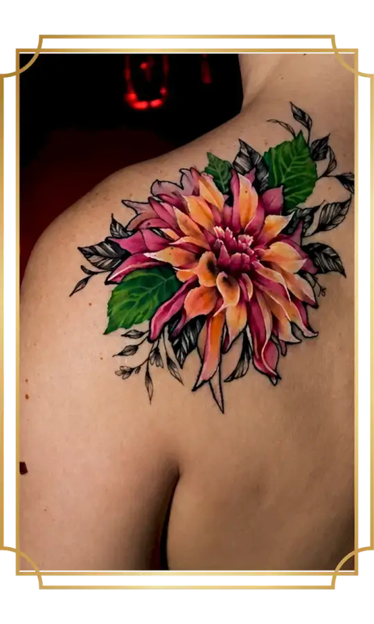 Vibrant color dahlia shoulder tattoo with pink and orange petals, saturated green leaves and black illustrative foliage, created in San Marcos