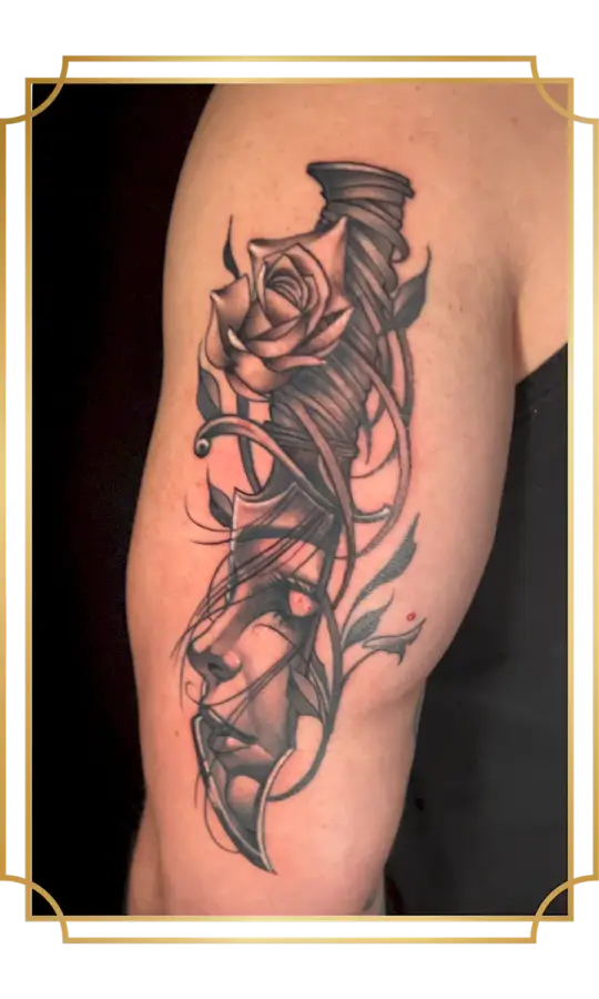 Black and gray surreal woman's face tattoo with rose and geometric linework on the upper arm