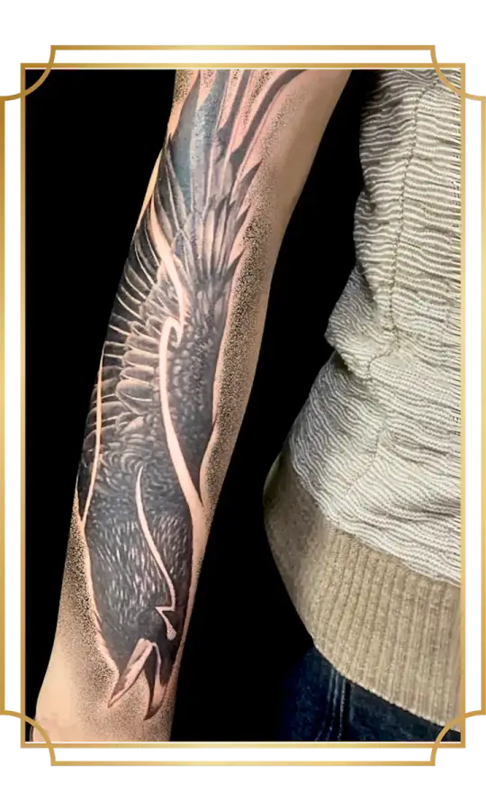 Black and gray raven tattoo with outstretched wings and dotwork shading on the forearm