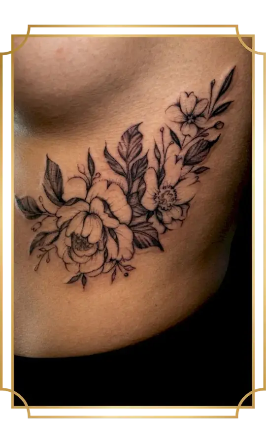 Floral fine-line rib tattoo by Alek the Saint, featuring a peony, open blossoms, detailed leaves and stipple shading flowing beneath the breast