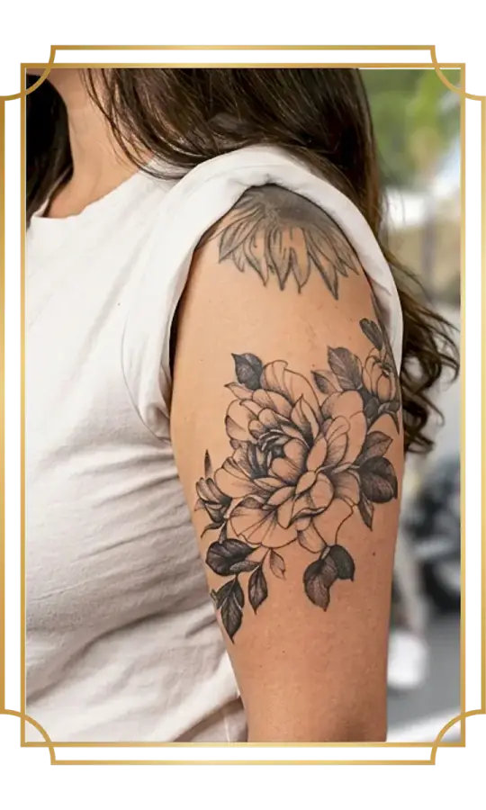 Floral fine-line peony bouquet wrapping the upper arm, with layered petals, stipple-shaded leaves and clean outlines by Alek the Saint