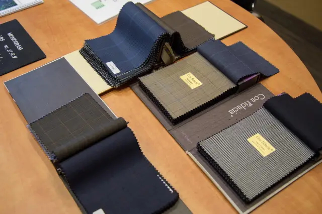 A Super 120 fabric book laid out with multiple fabric swatches to choose from to match your style profile.