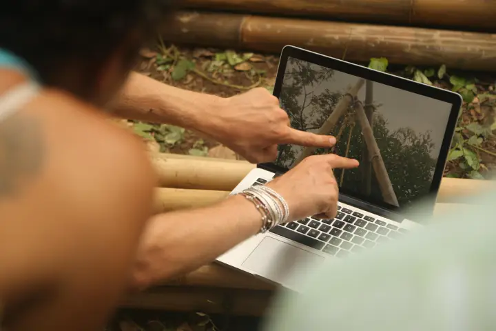 Reviewing a digital model of a bamboo structure on a laptop