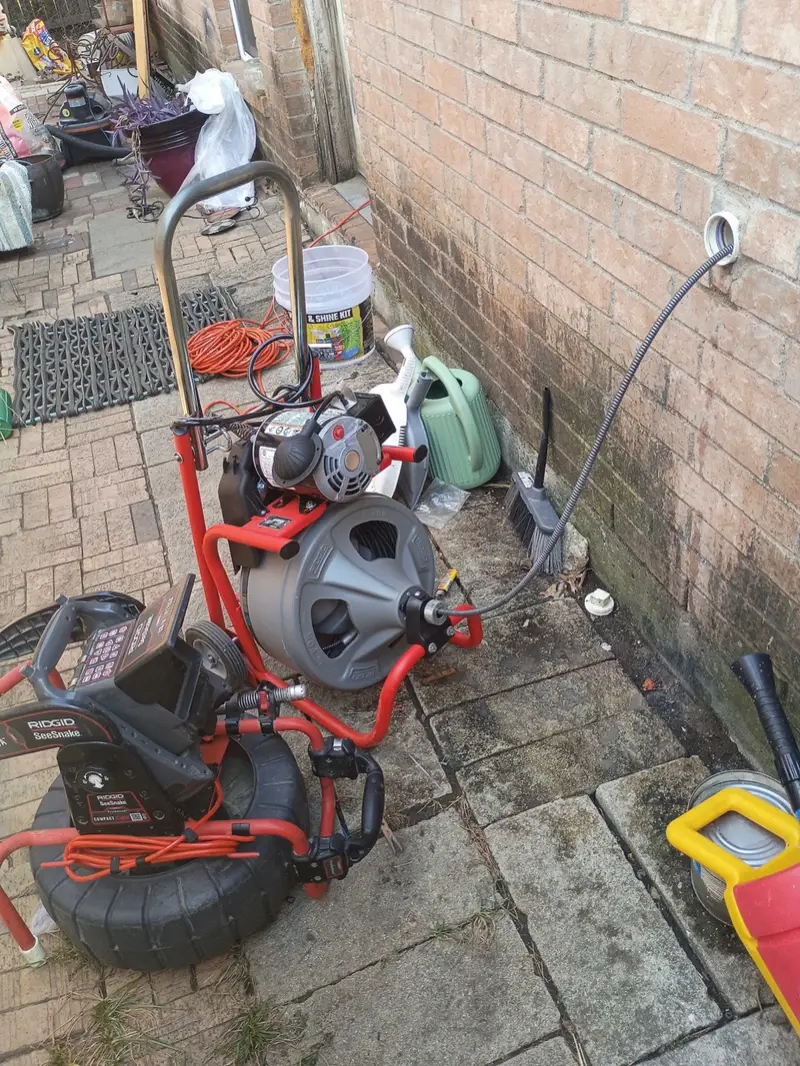Drain cleaning machine set up beside a home