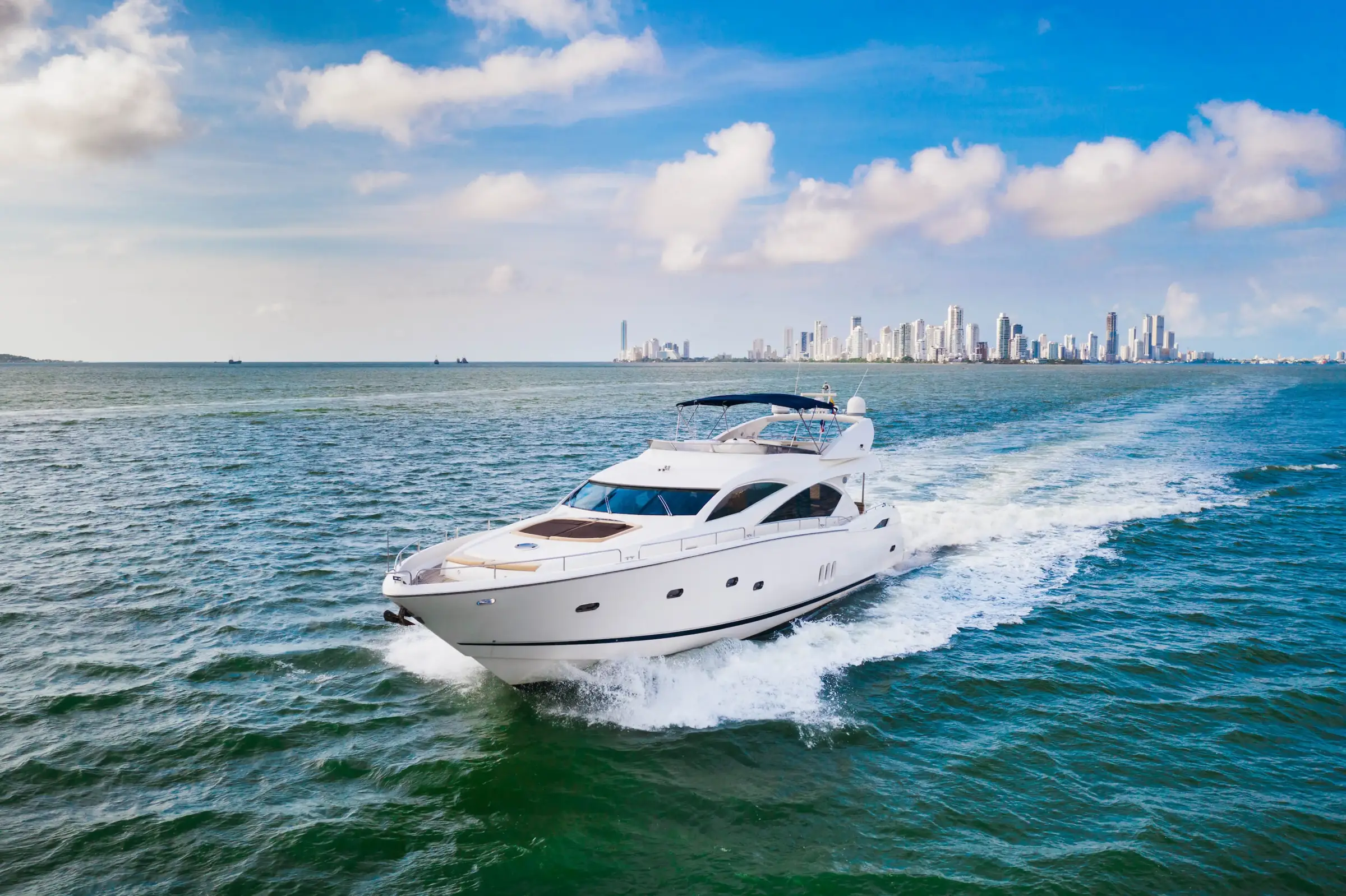 Yacht Martlet under way off Cartagena, the city skyline on the horizon behind her
