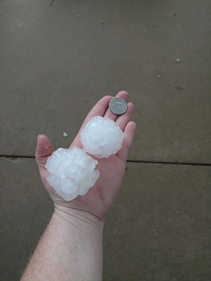 Hailstones in a homeowner's hand after a storm