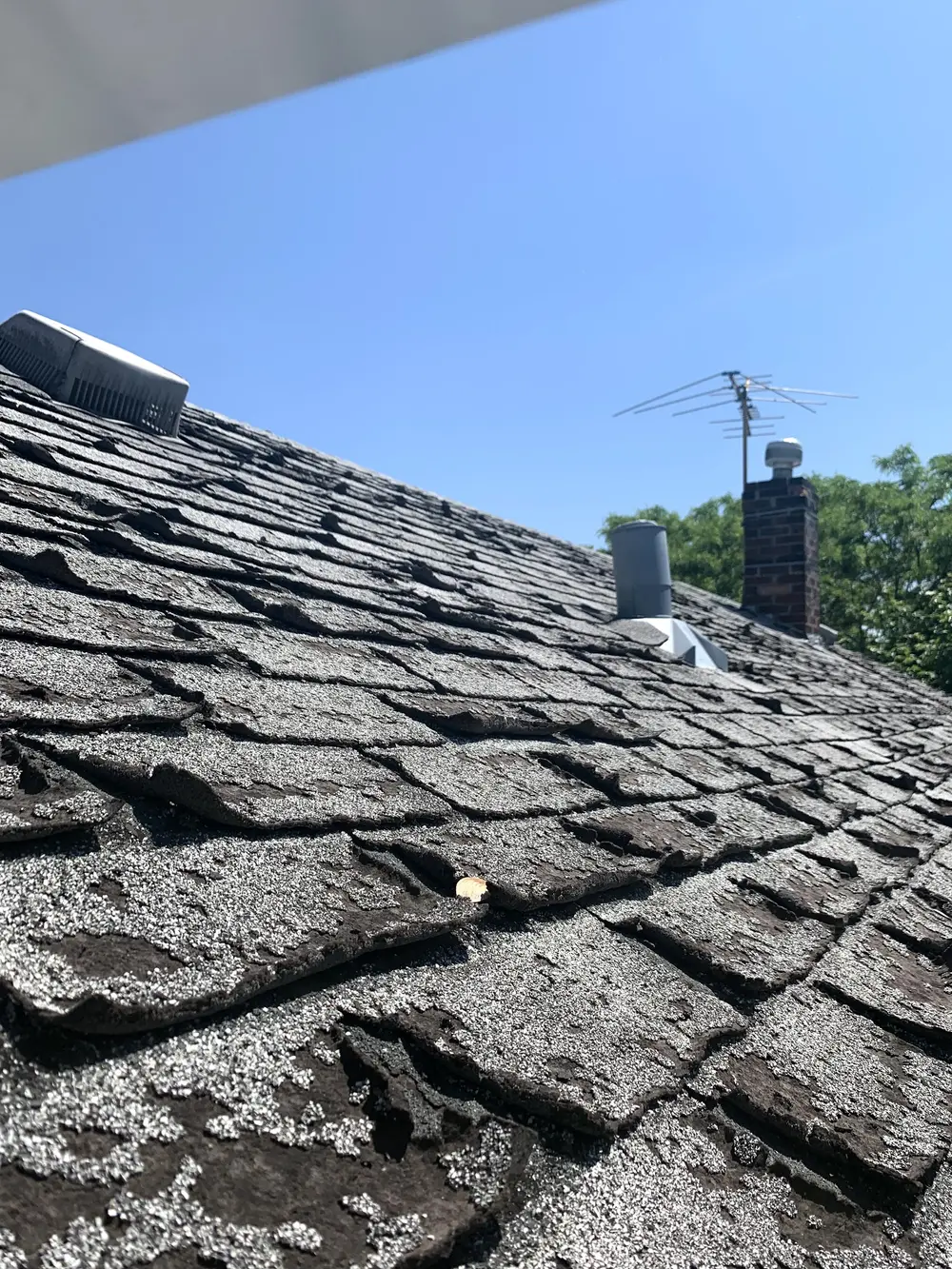 Storm-worn shingles on an older roof