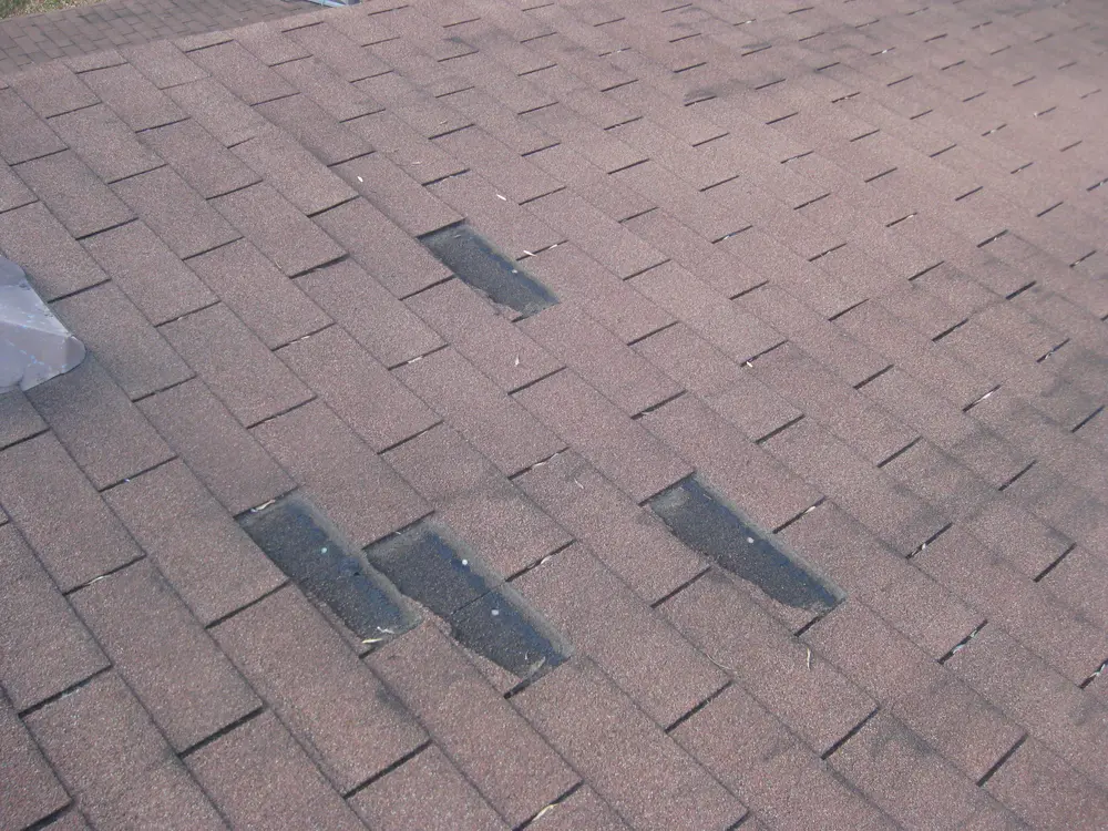 Missing shingles on a roof after a windstorm