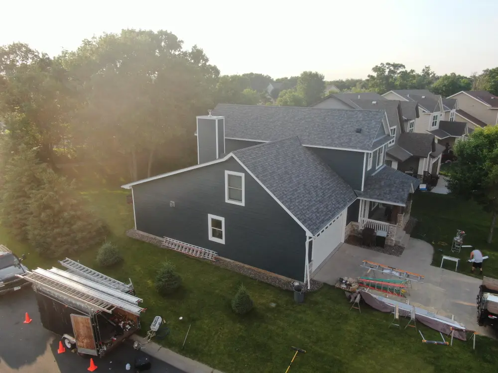 Back of a Minnesota home with new blue siding, drone photo