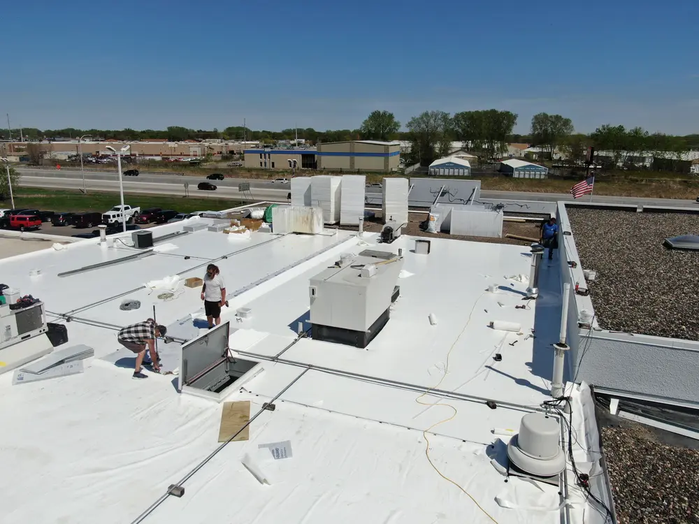 New white PVC membrane on a commercial flat roof with rooftop units