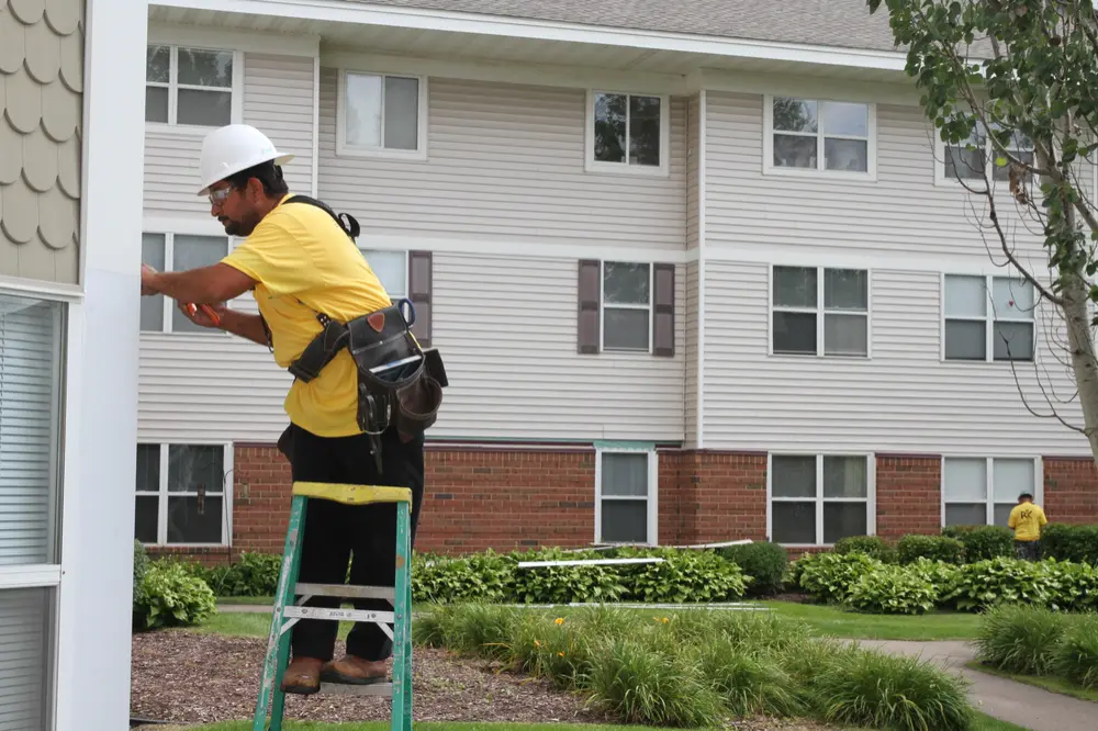 Repair King crew member on a ladder at a multi-family building in Oakdale, MN