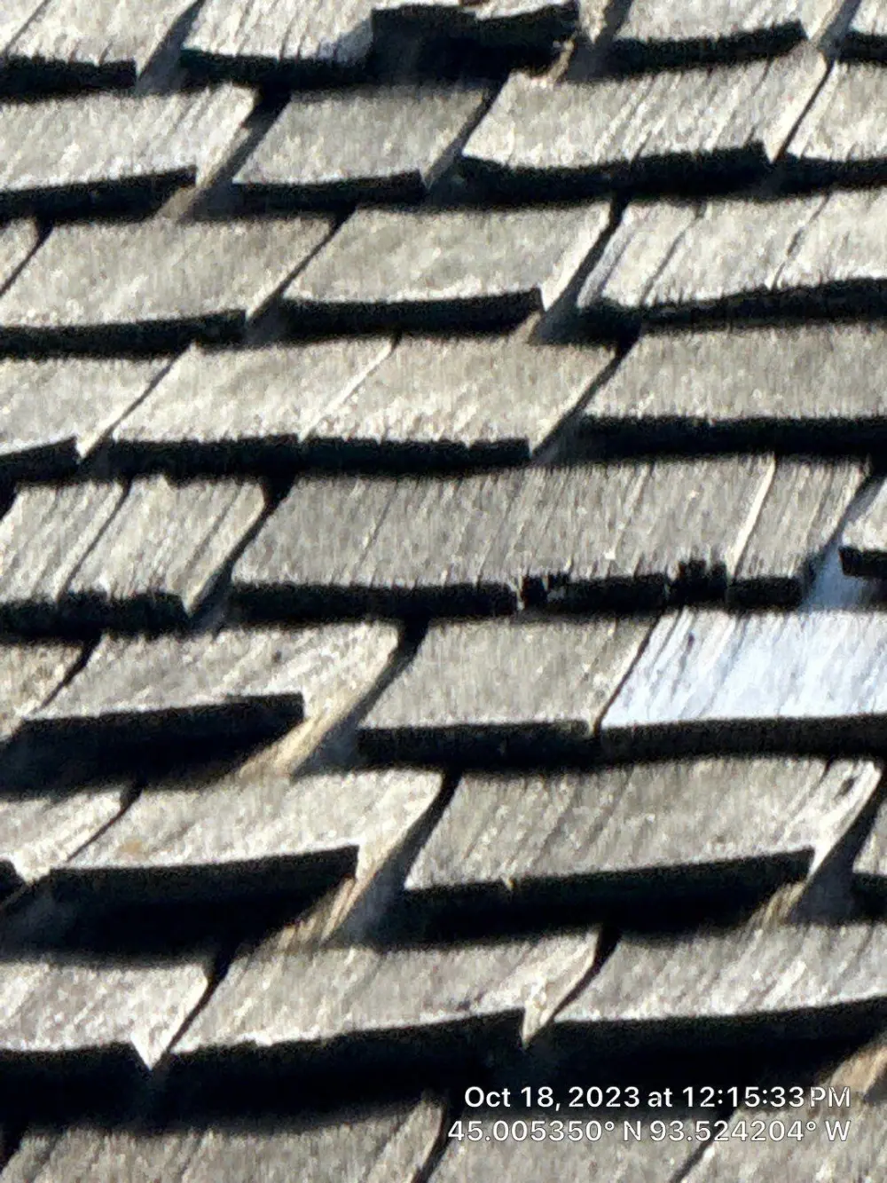 Loose and missing cedar shakes on an aging roof