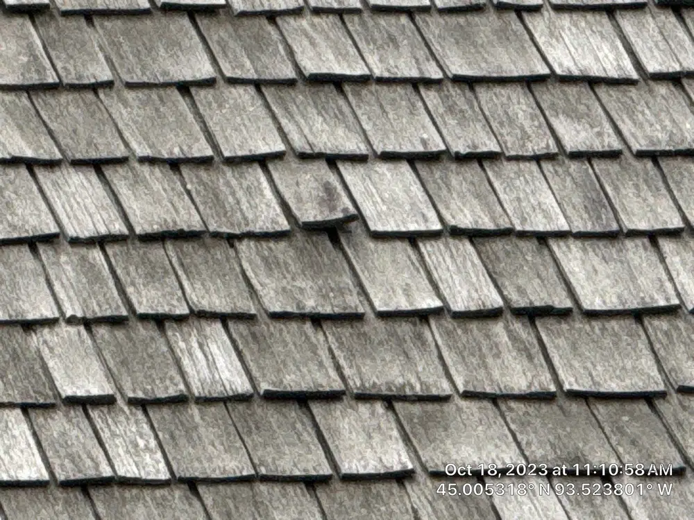 Weathered cedar shake roof showing age and storm wear