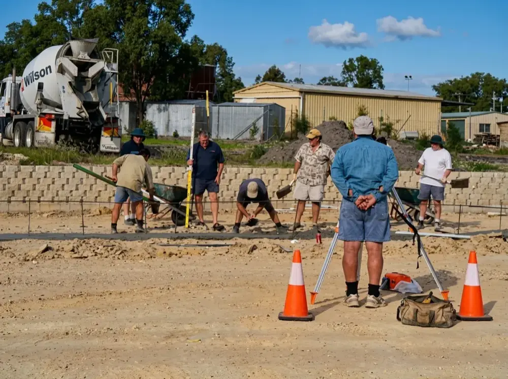 Volunteers and workers on a Goodness building site with a concrete truck
