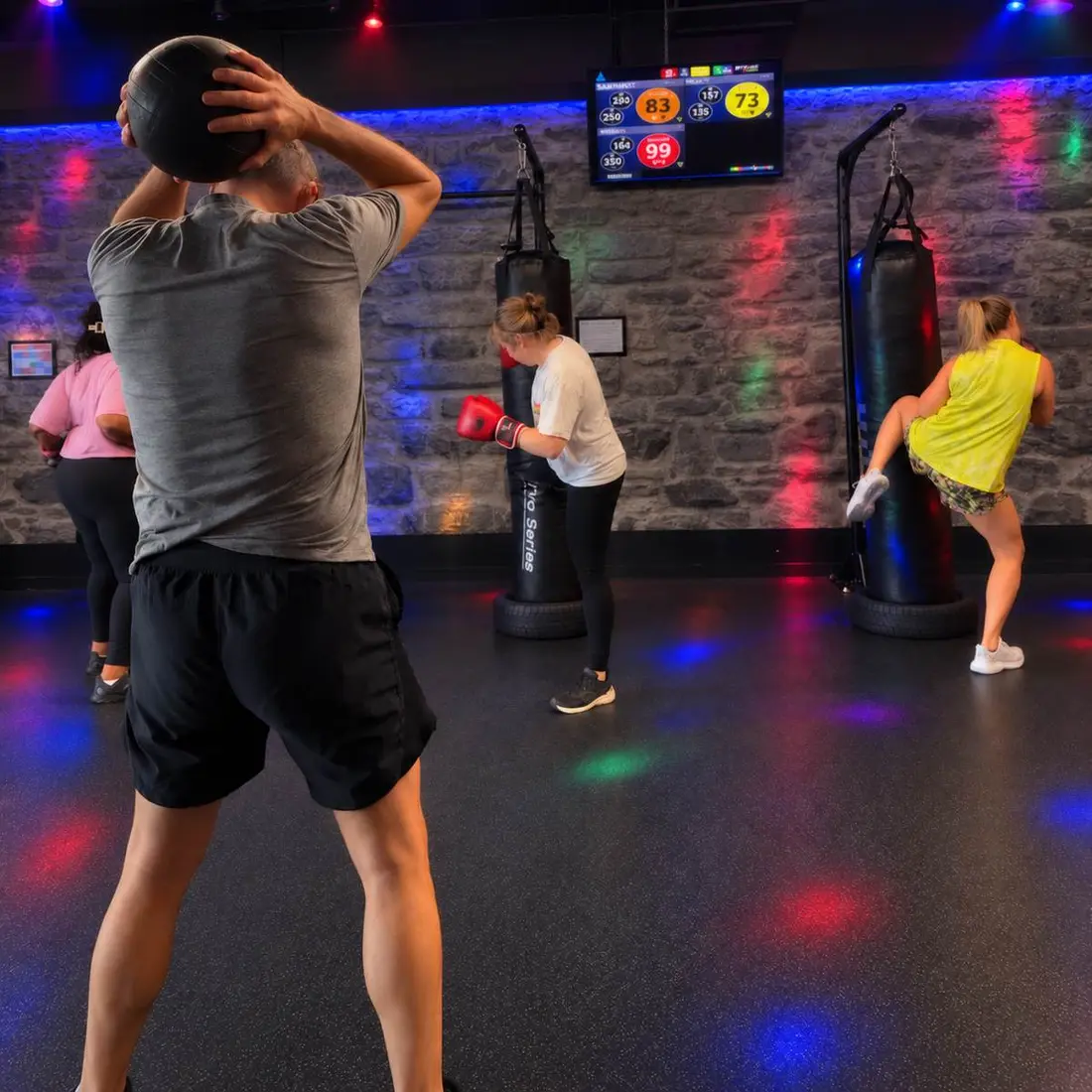 A KFIT class training on the heavy bags with their coach