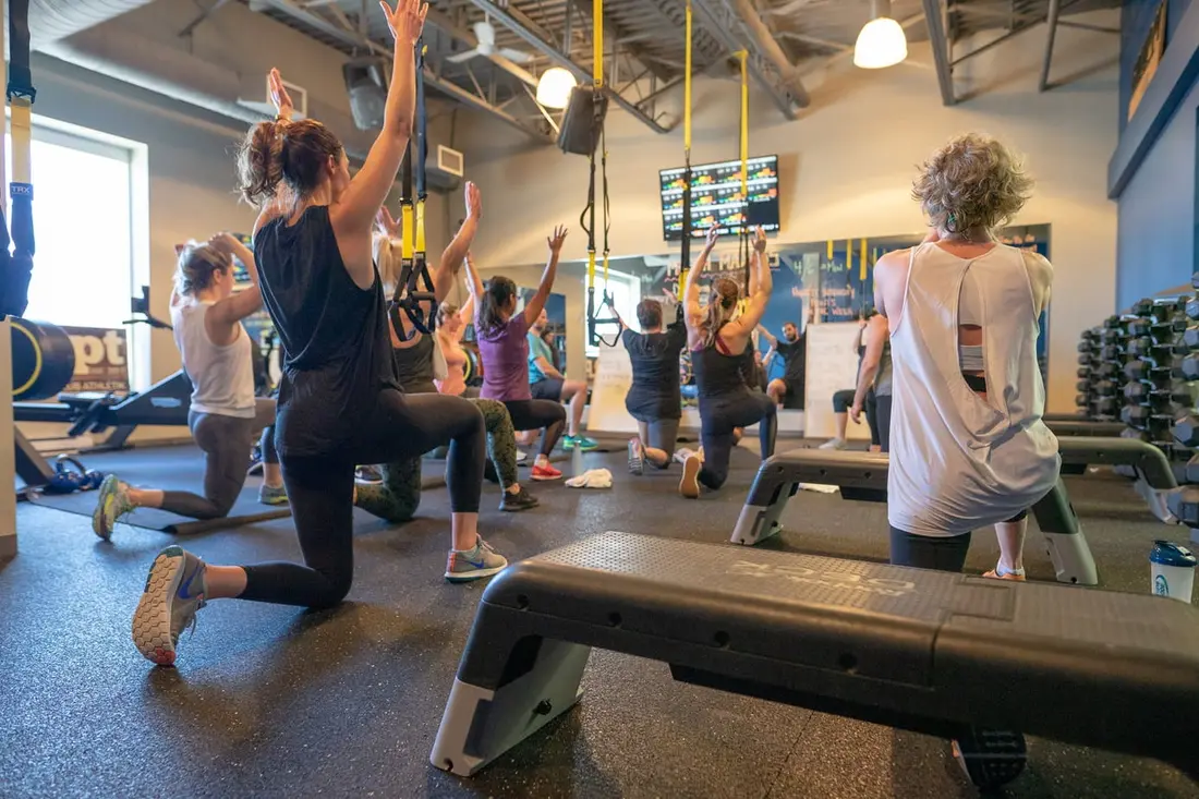 A Group PT class doing lunges together in the Group PT studio