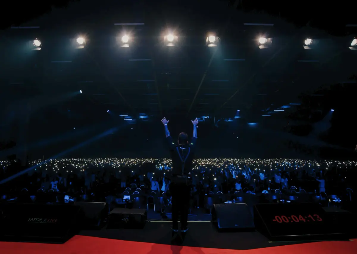 Kadu Molina em um palco diante do público
