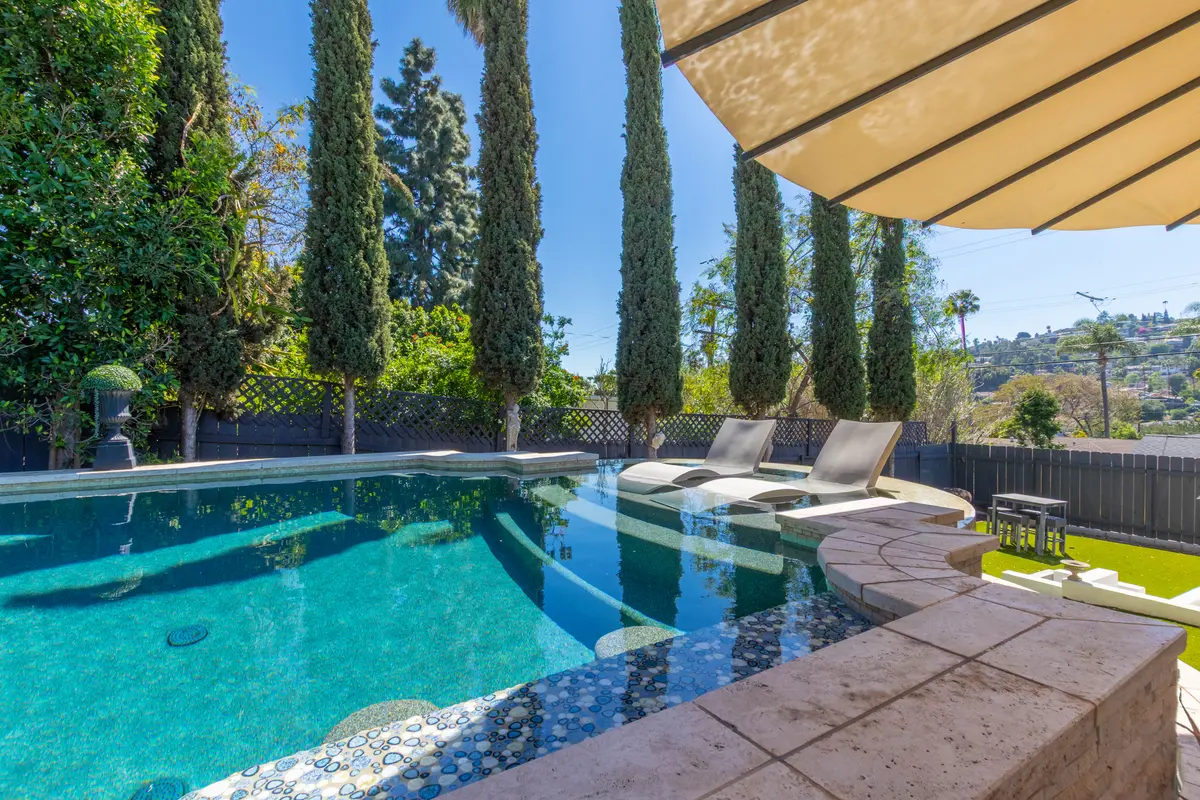 Freeform pool with sun shelf and lounge chairs