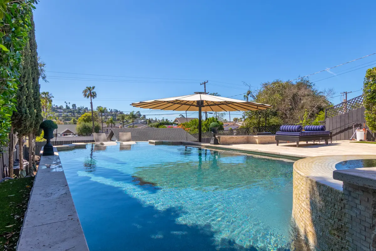 Pool with umbrella and hillside views