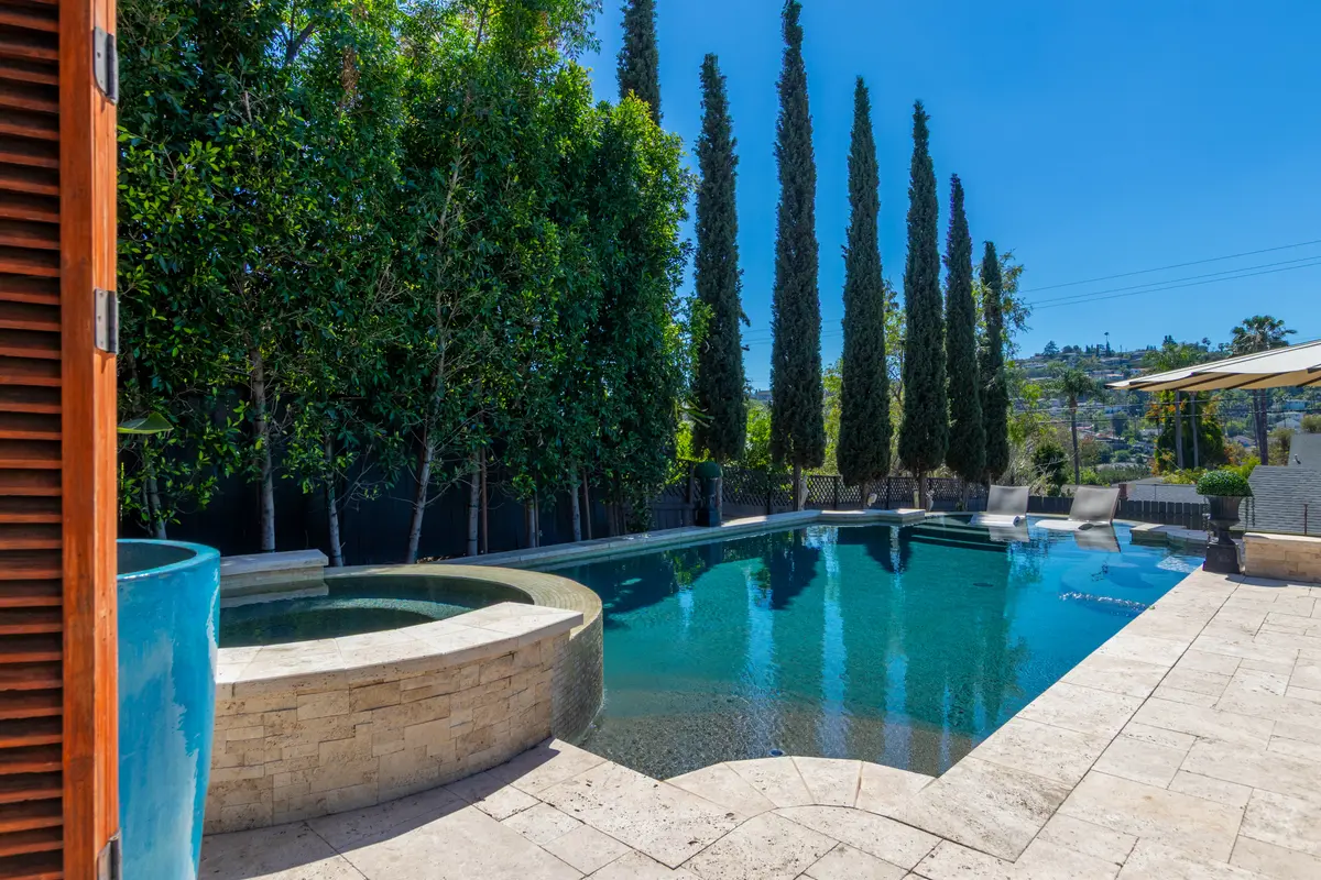 Pool and spa lined with tall cypress trees