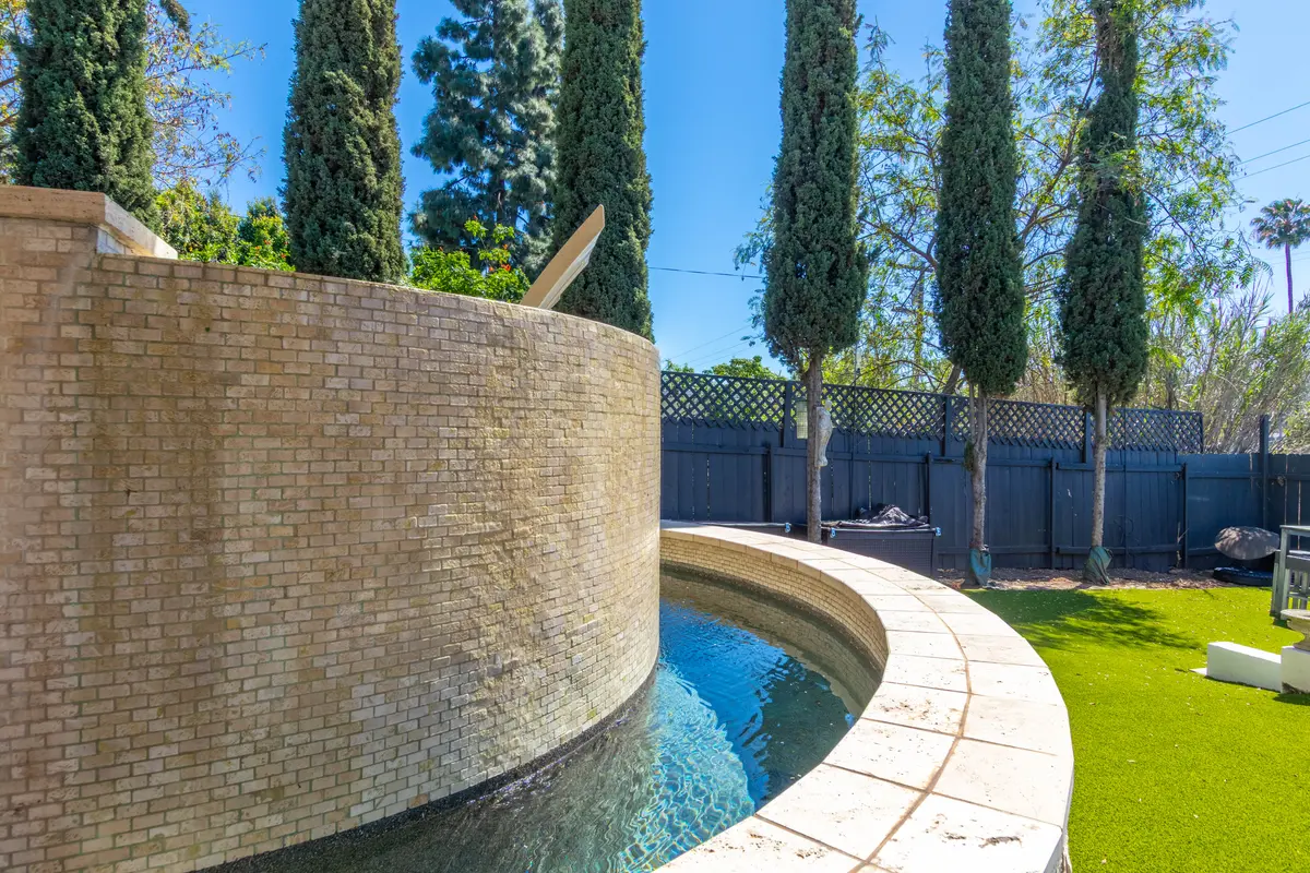 Curved stone wall wrapping a pool