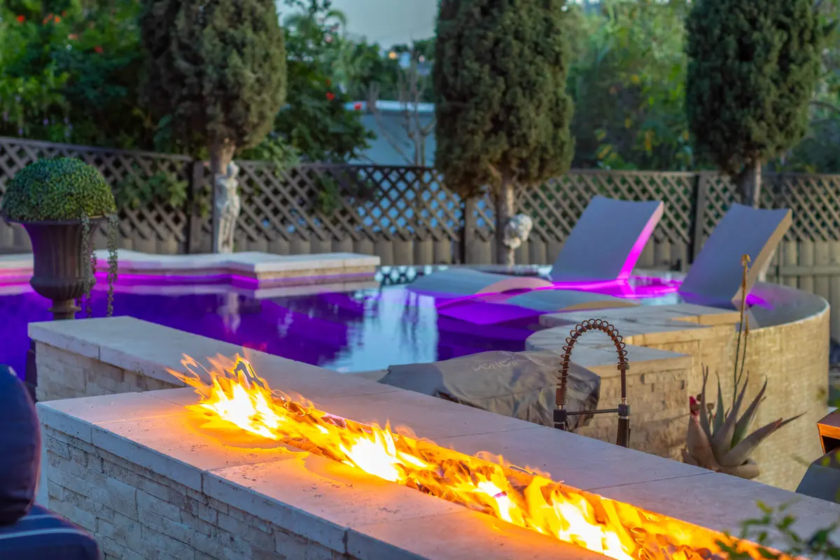 Raised stone spa spilling into the pool