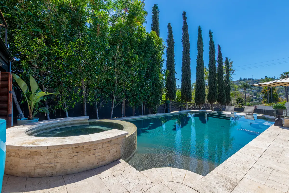 Raised stone spa spilling into the pool
