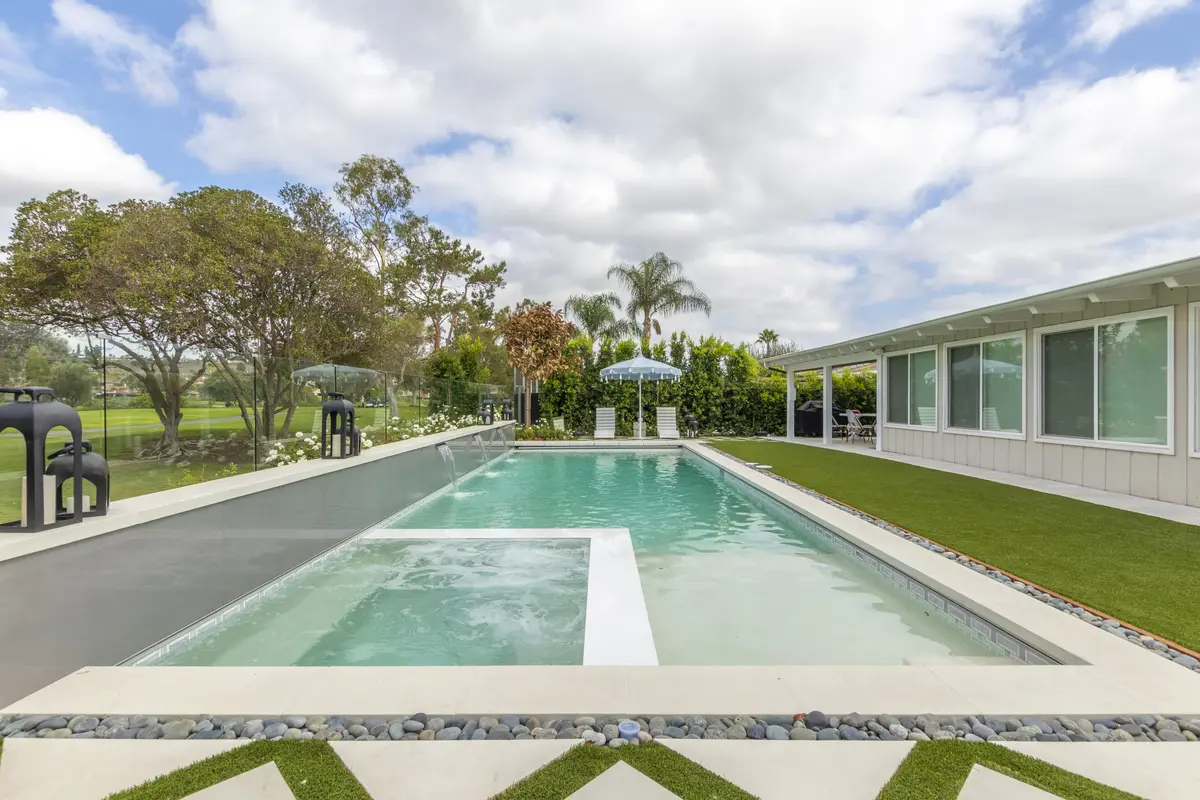 Paver patio with umbrella beside a modern pool