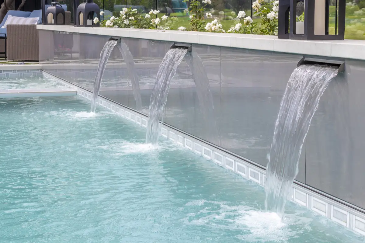 Sheer descent water wall spilling into a turquoise pool