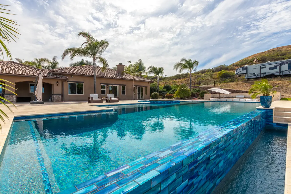 Glass-tile pool edge beside a home