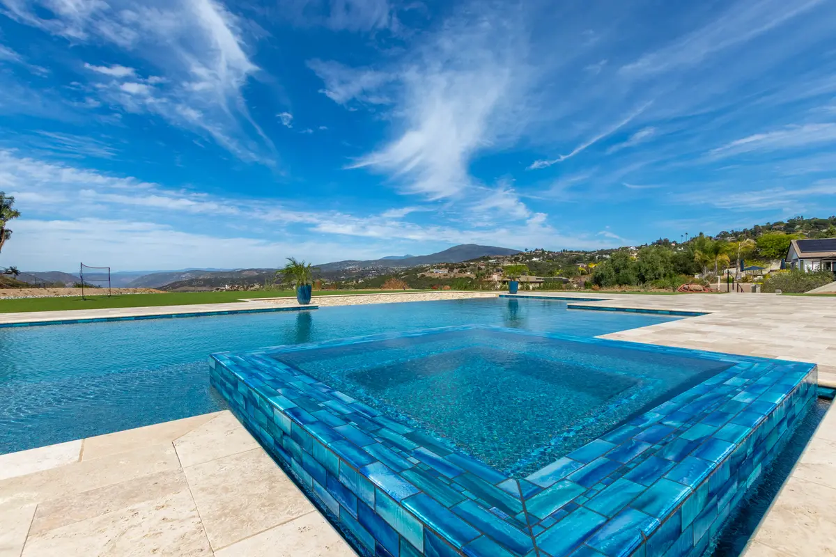Tiled spa and pool under a big blue sky