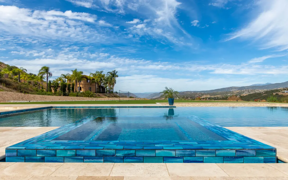 Blue glass-tile spa under a wide sky