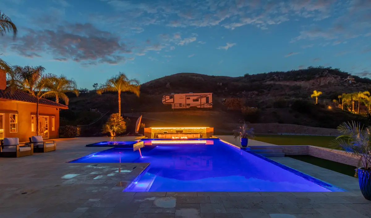 Pool and palm trees lit up in the evening