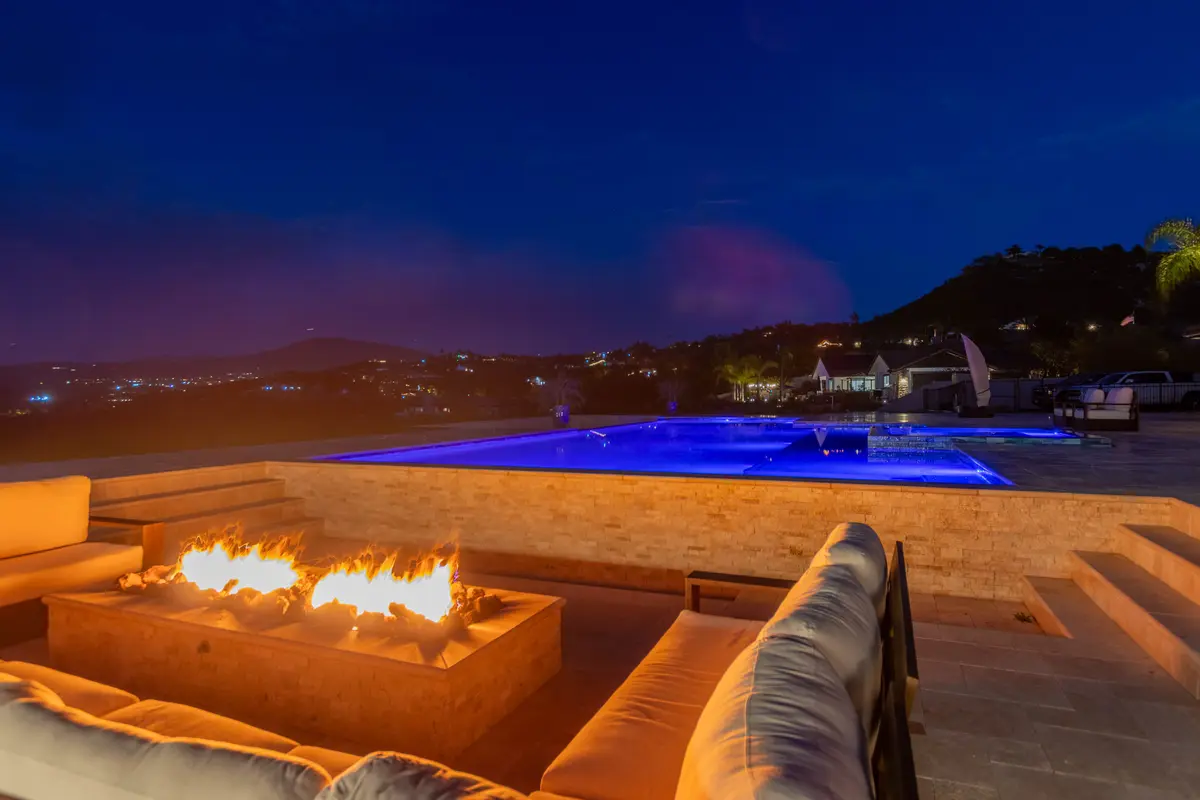 Resort backyard pool glowing at dusk with palm trees