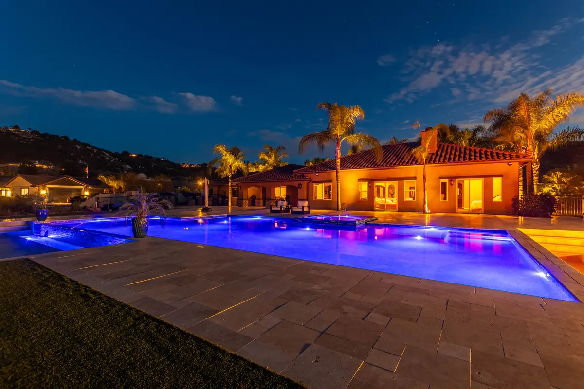 Pool, palms and home glowing at dusk