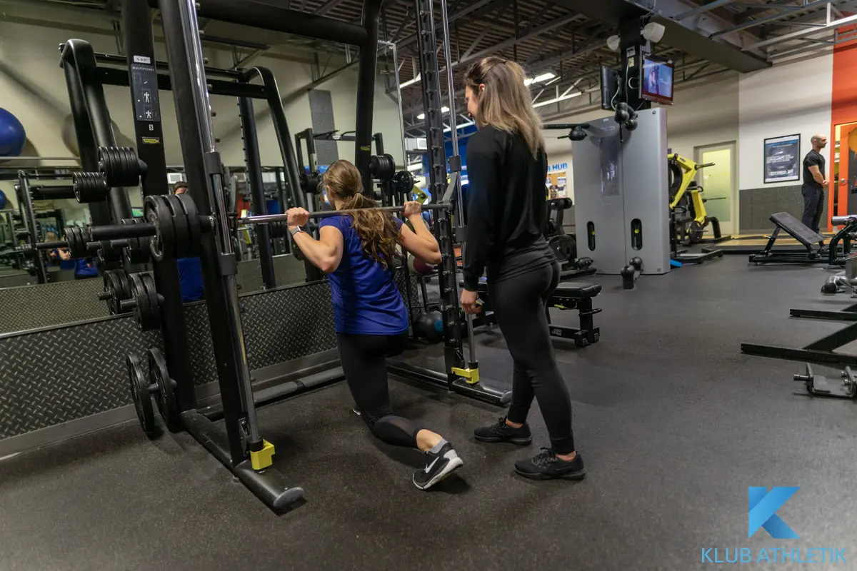 A Klub 20 personal trainer coaching a client through a lunge