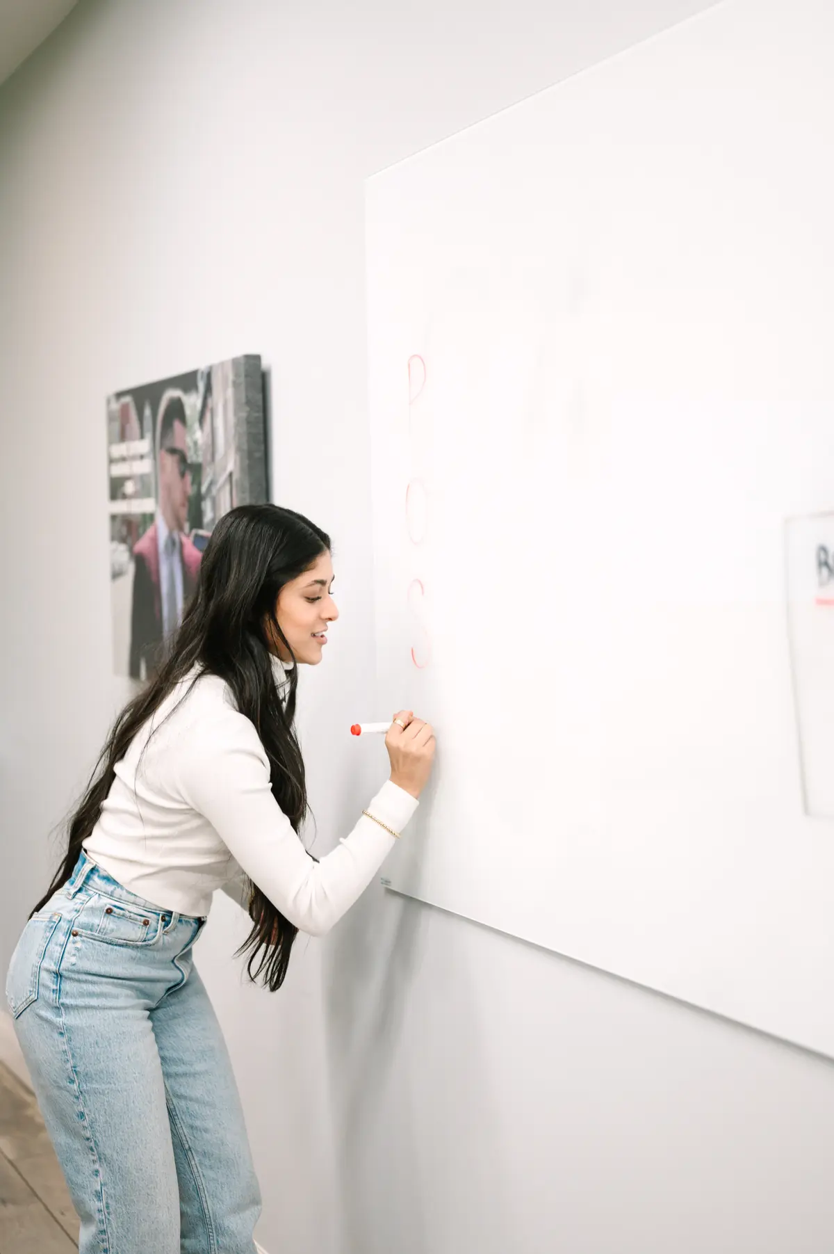 Amber Farooqui working through business ideas at a whiteboard